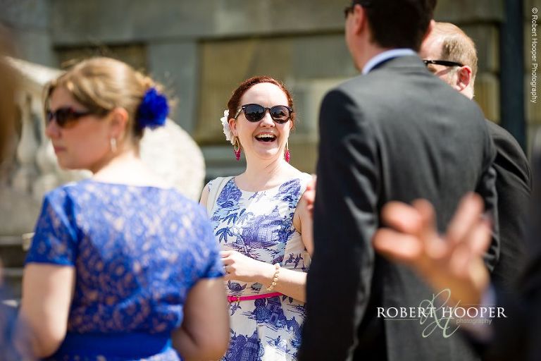 Wedding guests laughing and enjoying the sunshine on wedding day at Botleys Mansion Surrey