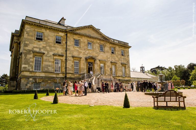 Bride and bride groom mingling with their guests at outside champagne reception at Botleys Mansion Chertsey Surrey