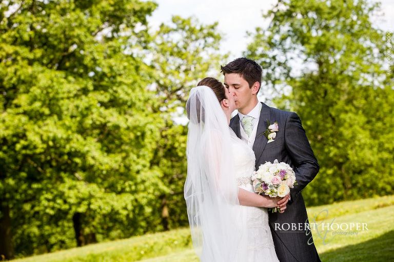 Bride and groom share a kiss in the grounds of Botleys Mansion Surrey after their civil wedding ceremony