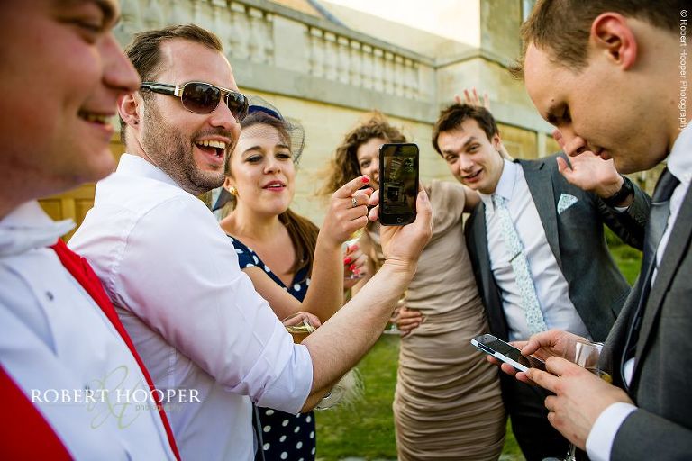 Wedding guests taking selfies at wedding reception at Botleys Mansion Chertsey Surrey