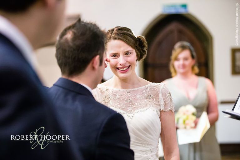 Groom wipes aways bride's tears during their wedding vows at St. Anne's Church Surrey