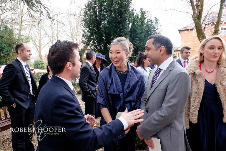 Groom receiving congratulations from wedding guests after marriage ceremony at St. Anne's Church Surrey
