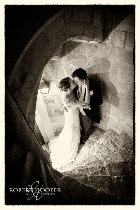 Bride and groom together at bottom of stone stairwell at Farnham Castle Surrey