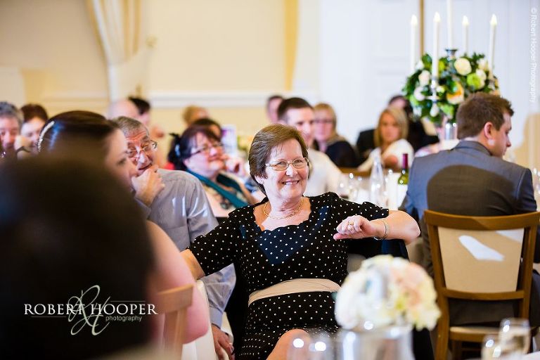 Guest laughing at speeches during wedding breakfast at Farnham Castle Surrey