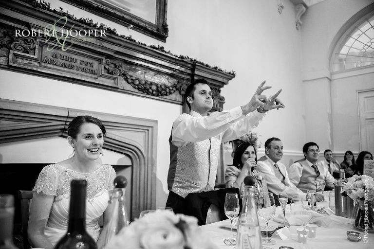 Groom delivers his speech from top table at wedding breakfast at Farnham Castle Surrey