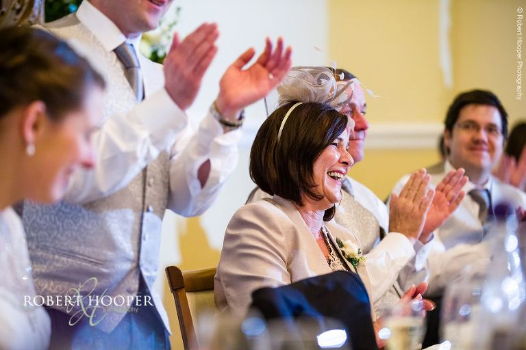 Guests clapping during speeches at wedding breakfast held at Farnham Castle Surrey