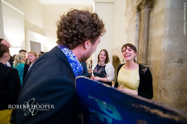 Wedding guest laughing at caricature drawing made by artist on wedding day at Farnham Castle Surrey