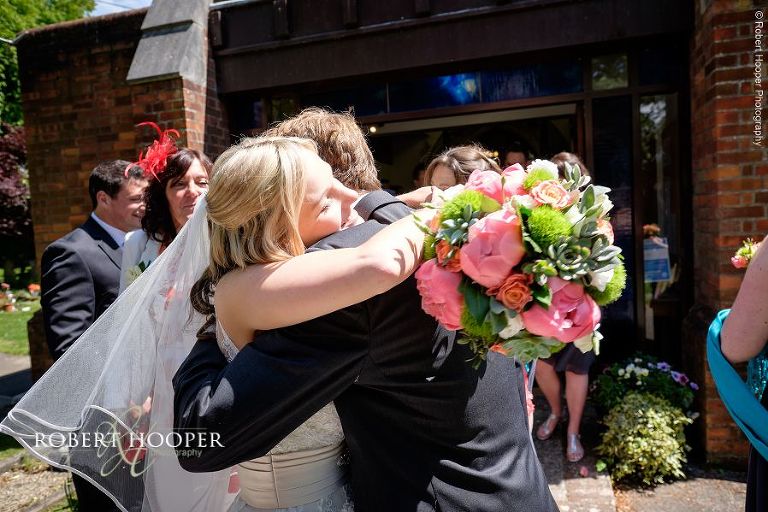 Wedding guests hugs bride after her wedding ceremony outside All Saints' Hordle Hampshire
