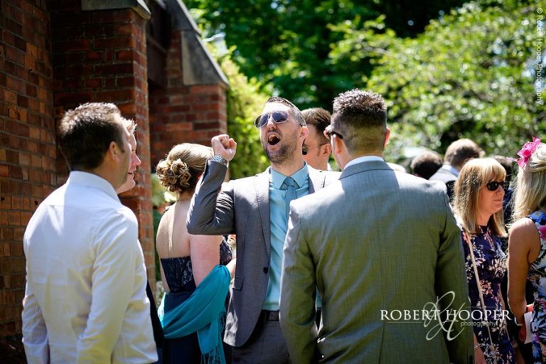 Wedding guests chatting and laughing outside the church after wedding ceremony at All Saints' Hordle Hampshire