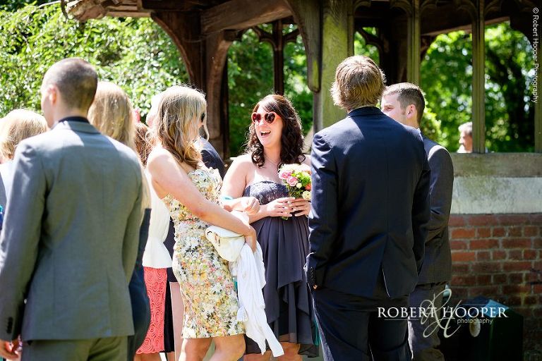 Bridesmaid wearing toy sunglasses after wedding ceremony at All Saints' Hordle Hamsphire