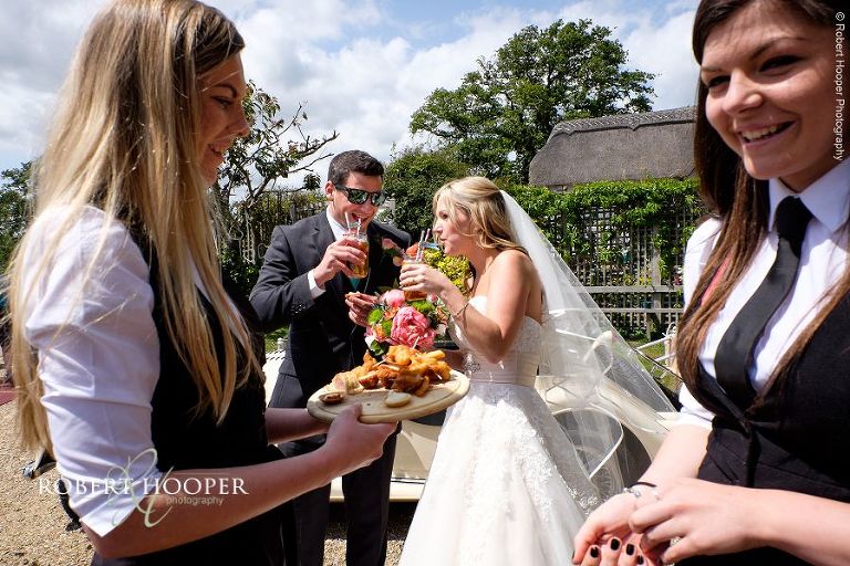 Bride and groom served Pimms by waitresses at wedding reception at The Three Tuns Dorset