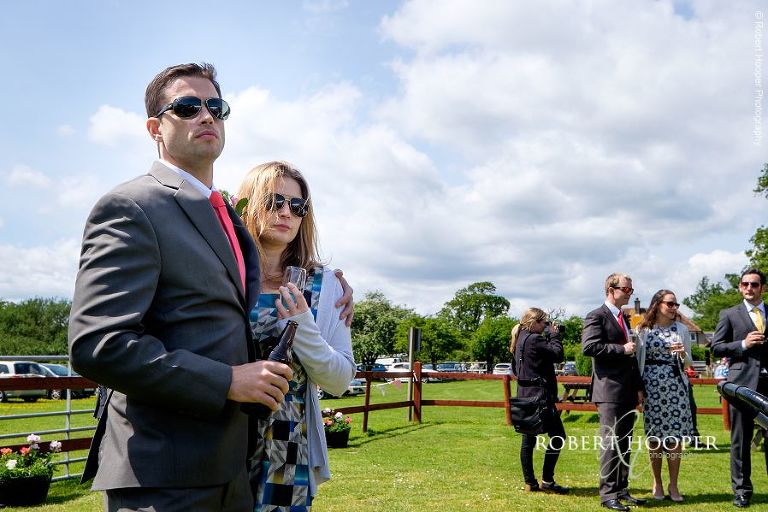 Wedding guests wearing sunglasses on hot summer day at garden wedding reception at The Three Tuns Bransgore, Dorset