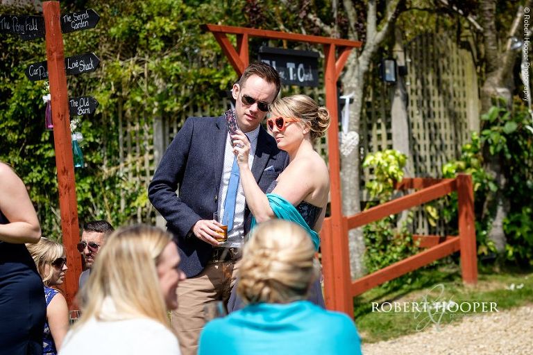 Bridesmaid and wedding guest checking out their selfie on iphone at wedding reception in the garden of The Three Tuns Bransgore, Dorset