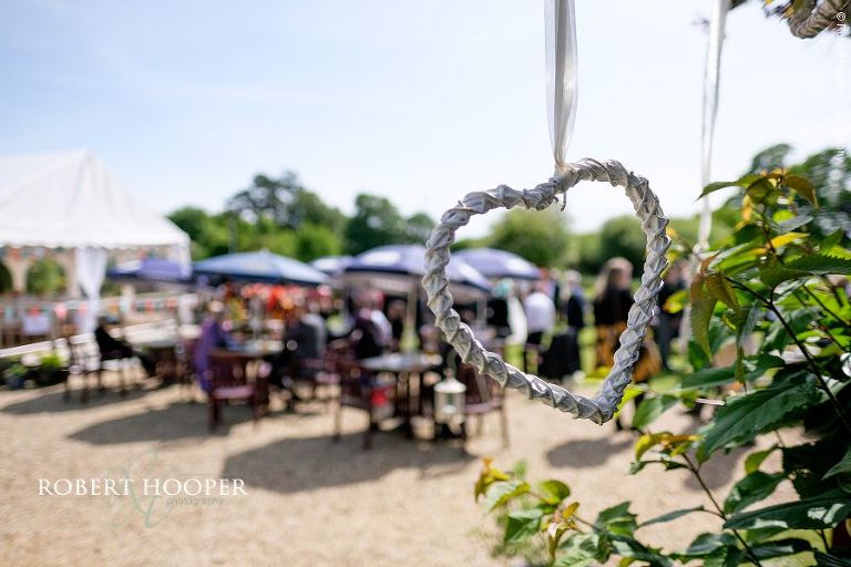 Hanging love heart decoration at village fayre themed wedding reception held in the garden of The Three Tun , Bransgore, Dorset