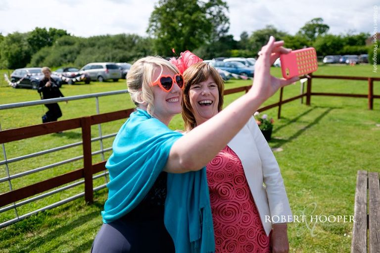 Bridesmaid and mother of the bride taking selfie on wedding day at The Three Tuns Bransgore Dorset