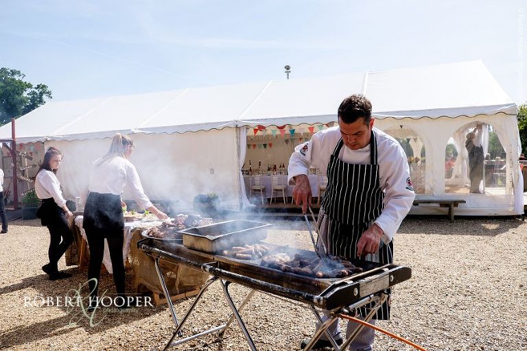 Chef at The Three Tuns Bransgore Dorset preparing barbeque food for village fayre themed wedding reception in the marquee