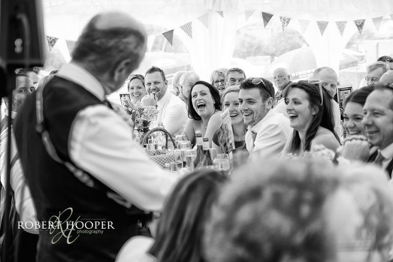 Father of the bride plays a song about his daughter on the ukelele as part of his speech at wedding reception in the marquee at The Three Tuns Bransgore Dorset