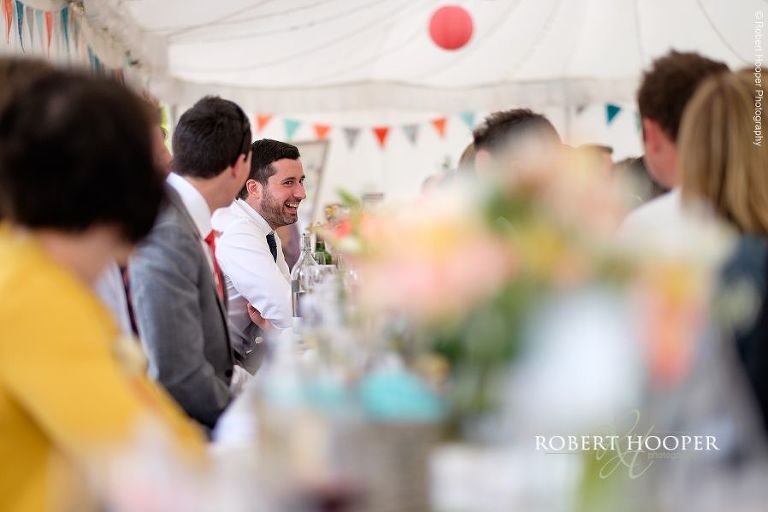 Wedding guests seated at picnic style tables at wedding reception in the marquee at The Three Tuns Bransgore Dorset
