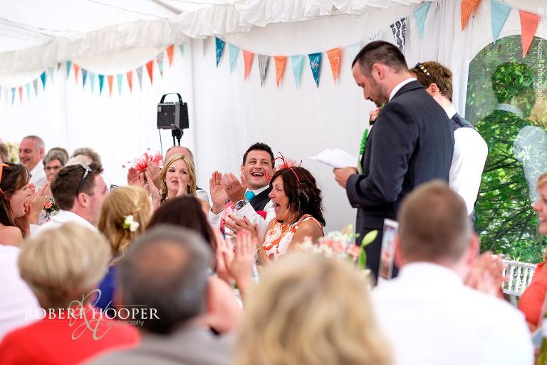 Wedding guests enjoying best man's speech at wedding breakfast in the marquee of The Three Tuns Bransgore Dorset