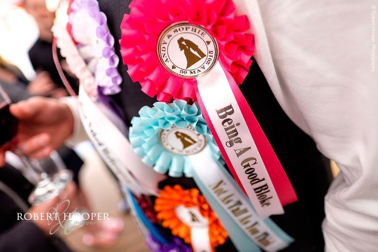 Rosette award ribbons on groom's chest presented by best men in excellent speech at wedding breakfast in the marquee at The Three Tuns Bransgore Dorset