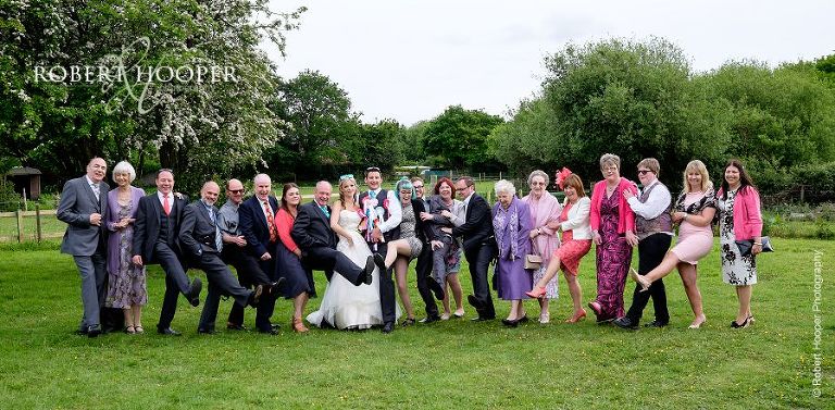 Wedding party family group knees up shot in gardens of The Three Tuns Bransgore Dorset