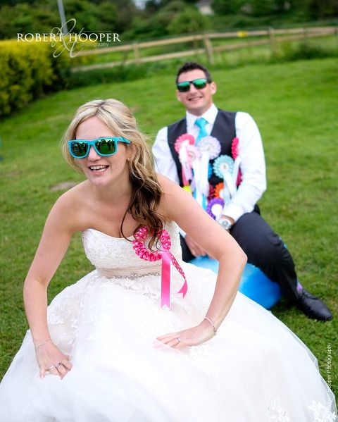Bride and groom trying out space hopper balls at their wedding reception in the gardens of The Three Tuns Bransgore Dorset