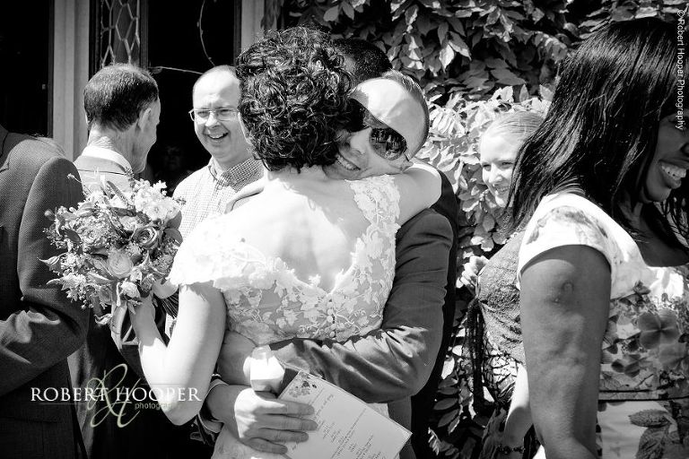 Bride gets a hug from one of her wedding guests after her wedding ceremony at Eastwell Manor Ashford Kent