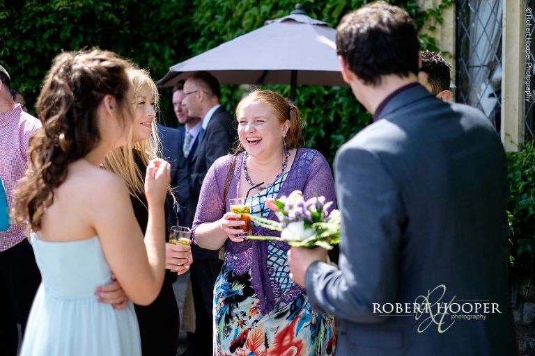 Guests enjoying some Pimms in the gardens of Eastwell Manor Kent on summer wedding day