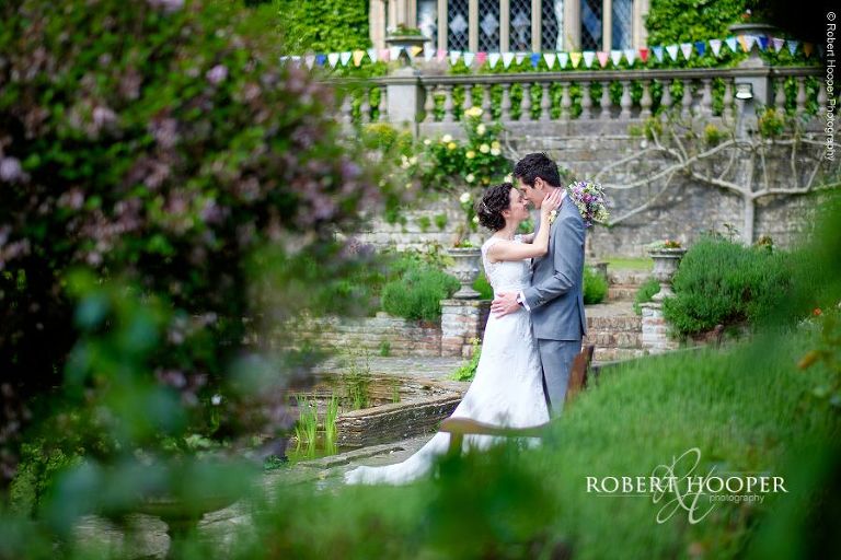 Bride and groom hold each other in an embrace in the walled garden on their wedding day at Eastwell Manor Ashford Kent