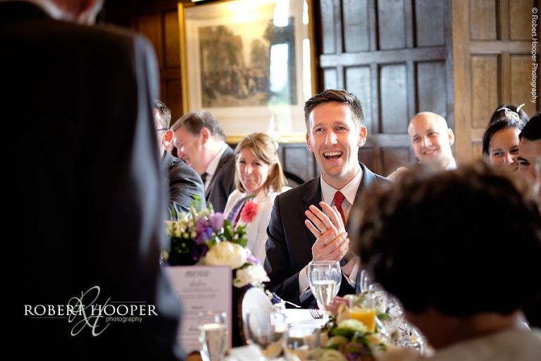 Wedding guests enjoying and laughing at speeches during wedding breakfast at Eastwell Manor Ashford Kent