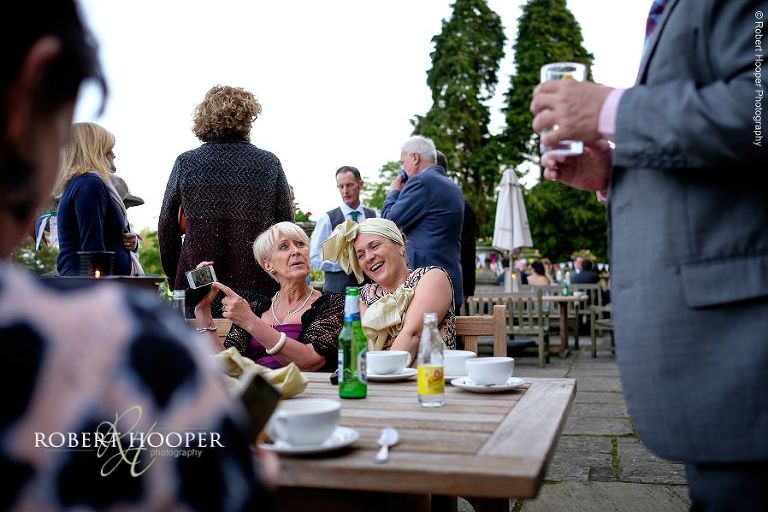 Guest wearing head dress made from wedding chair sash at wedding drinks reception held at Eastwell Manor Ashford Kent