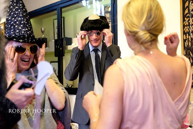 Wedding guests dressing up for photo booth pictures on wedding day at Eastwell Manor Ashford Kent
