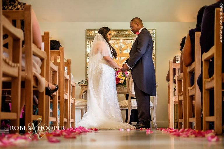 Bride and groom face each other and say their wedding vows during civil ceremony at Oaks Farm in Surrey