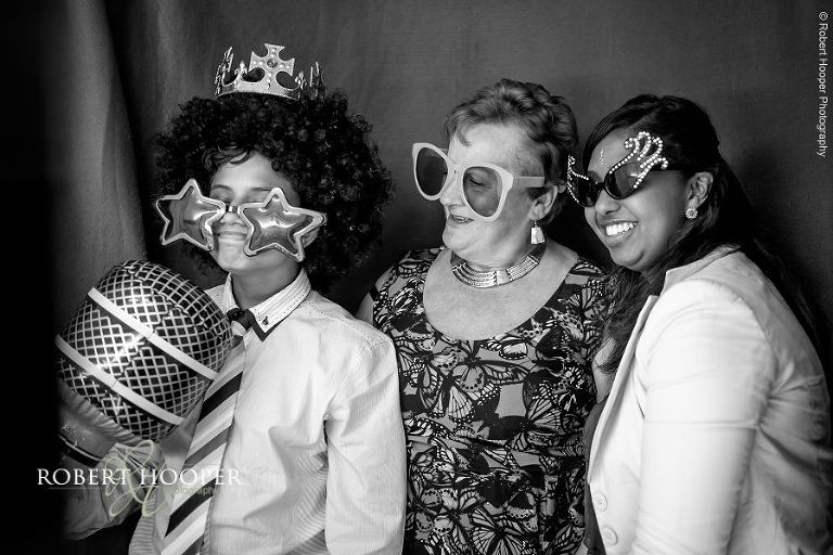 Wedding guests dressed up in fun sunglasses for photo booth pictures at wedding reception at Oaks Farm Surrey