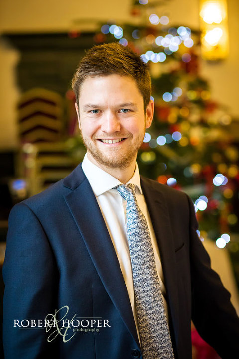 Groom portrait in front of Christmas tree
