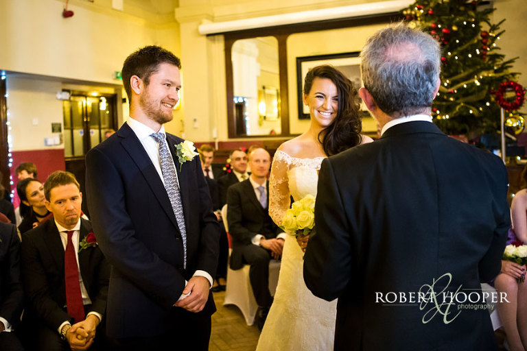 Bride and groom during civil wedding ceremony at Christmas time at The Rooms at Browns London