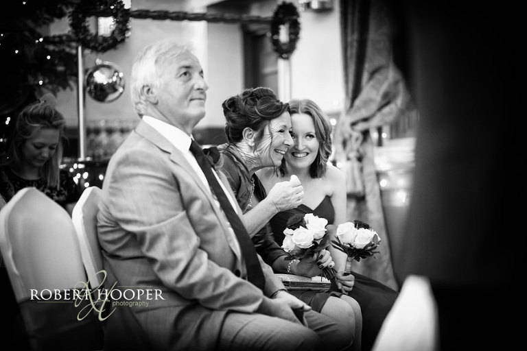 Bridesmaid and mother of the bride share smiles during civil wedding ceremony at The Rooms at Browns central London