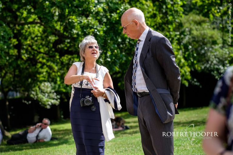 Wedding guests chatting outside Sacred Heart Church, Wimbedon in London on wedding day in August