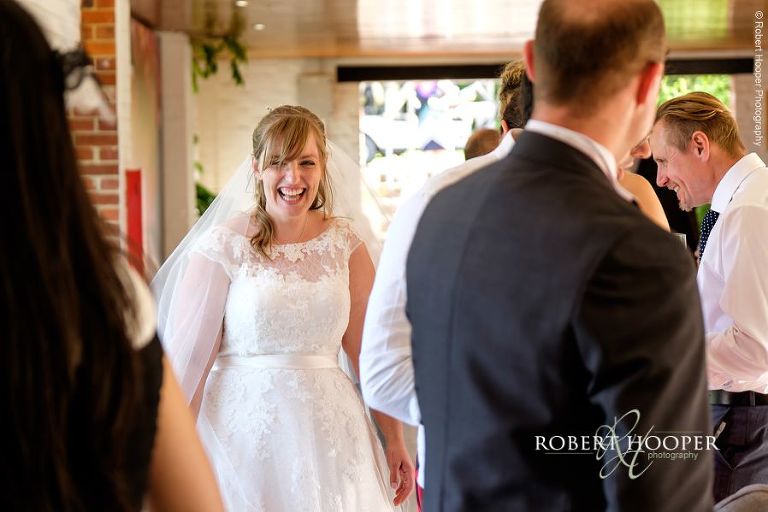 Bride enjoying her guests' company at Champagne reception on August wedding day at RHS Wisley, Woking in Surrey