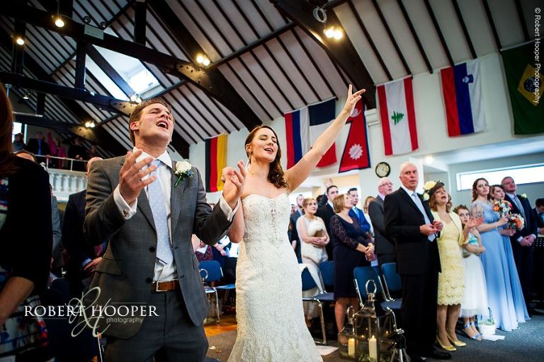 Bride and groom singing praise to the lord at wedding ceremony at Bookham Baptist Church Surrey