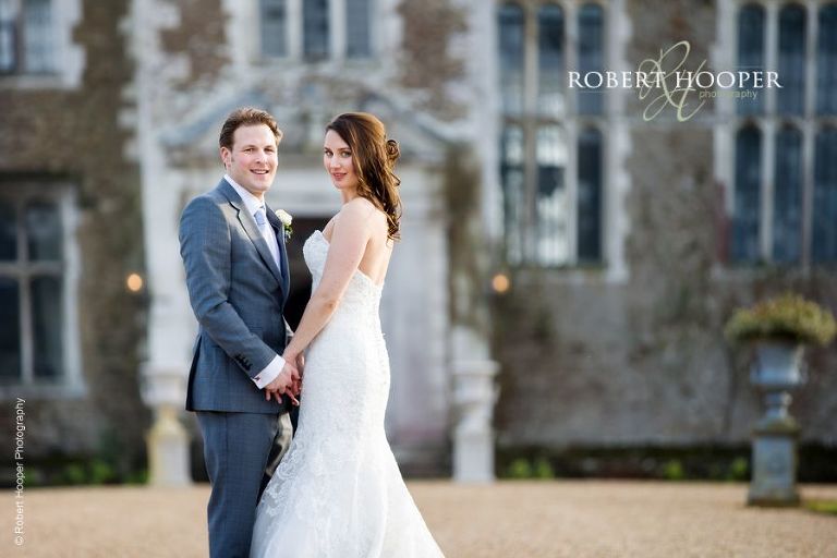 Bride and groom in front of the house at Loseley Park on their wedding day in March