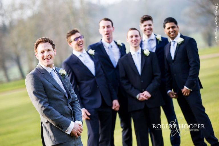 Groom and all his groomsmen in the grounds at Loseley Park Surrey on wedding day in March
