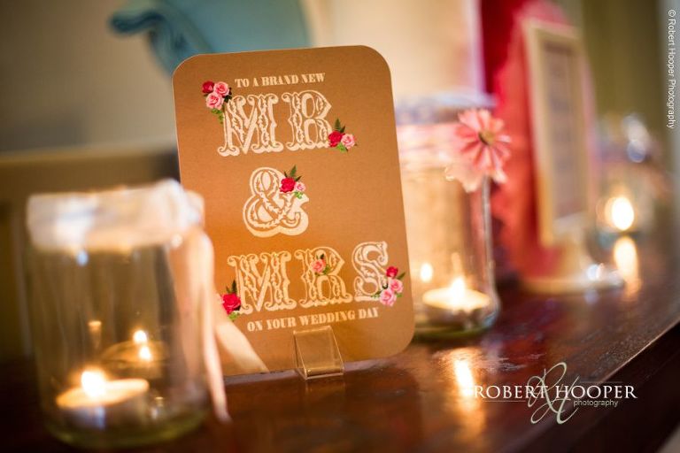 Table decorations and candles on table at wedding breakfast held in The Tithe Barn at Loseley Park Surrey