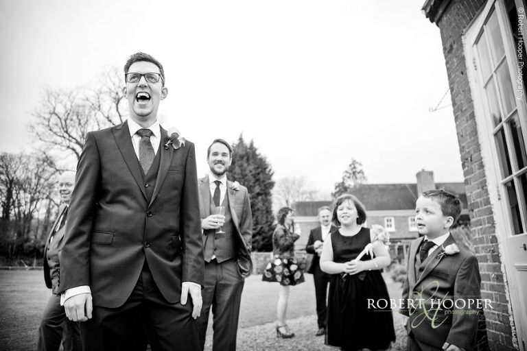 Groom laughing at groomsmen on his wedding day at Chilston Park in Lenham, Kent