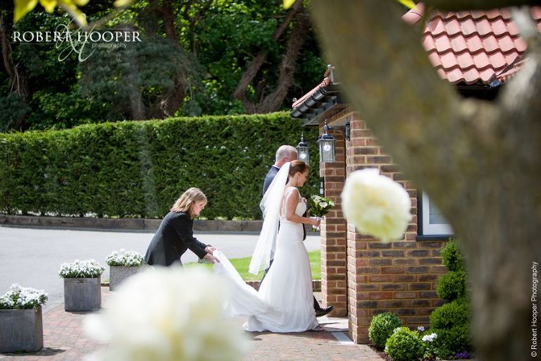 Bride entering the Stable for civil wedding ceremony at Oaks Farm Barn Shirley Surrey
