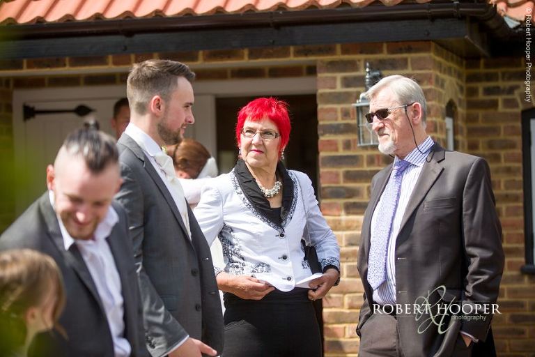 Wedding guests talking to groom after civil wedding ceremony at Oaks Farm Croydon Surrey