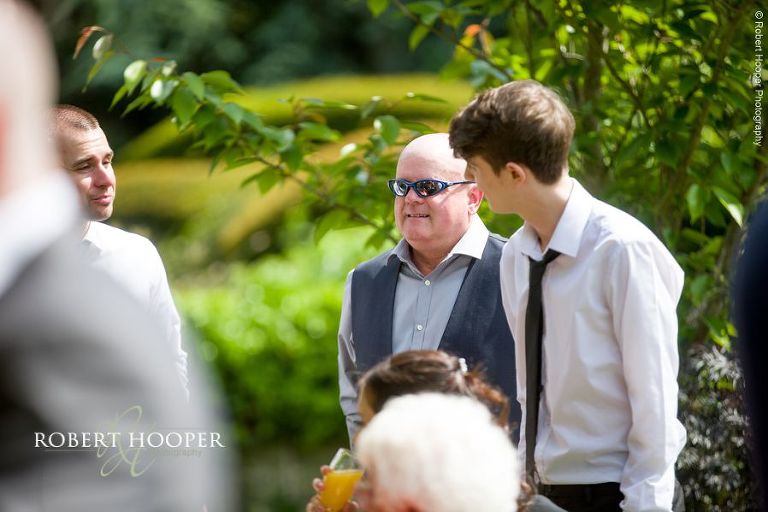 Wedding guests enjoying canapes in the sun on the lawn at Oaks Farm Barn Shirley Surrey
