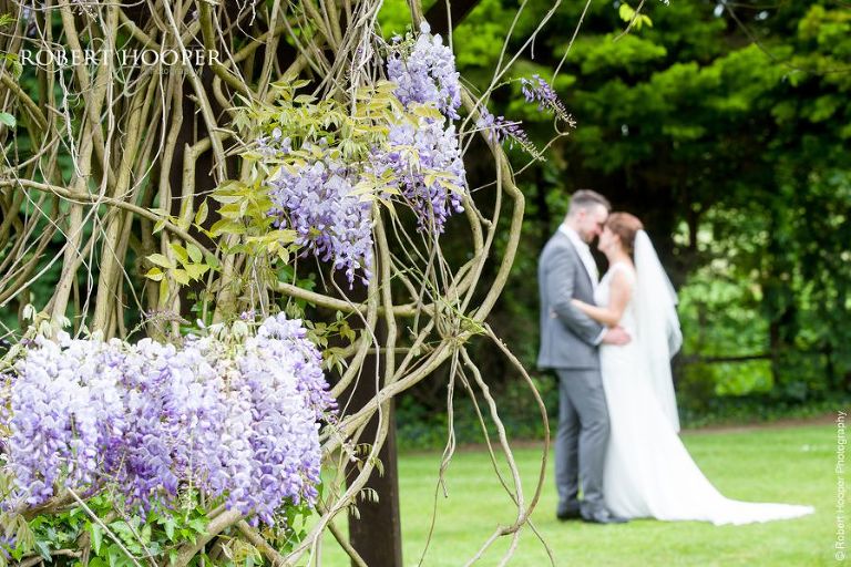 Bride and groom in the garden by Wisteria at Oaks Farm Barn Shirley Surrey