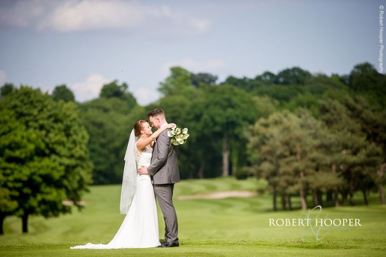 Bride and groom in a landscape on their wedding day in Surrey