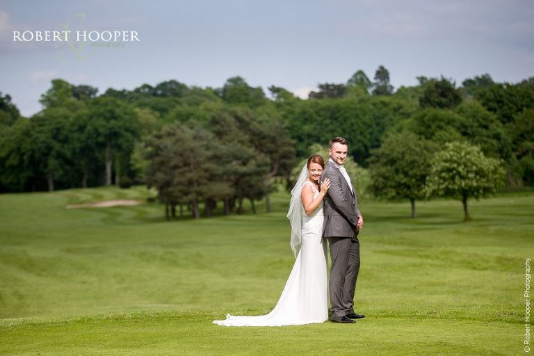Bride and groom in a landscape on their wedding day in Surrey
